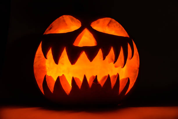istock Spooky halloween pumpkin on a black background 1266341634