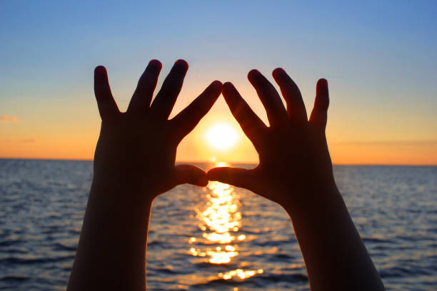 istock Baby hands on sunset background 1266341742