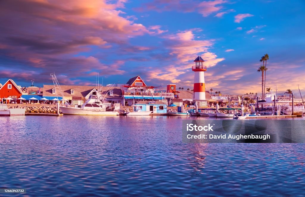 Oceanside Harbor at Sunset Colorful panorama at sunset with sky, waterfront and lighthouse reflected in the harbor. California Stock Photo