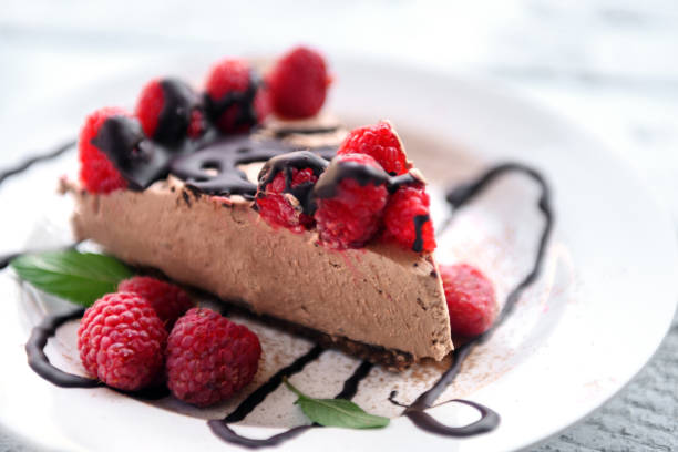 Delicious chocolate tartlet resting on a white plate with chocolate drizzle design
