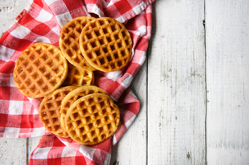 Belgian waffles and black coffee on a brown ceramic table. Copy space.