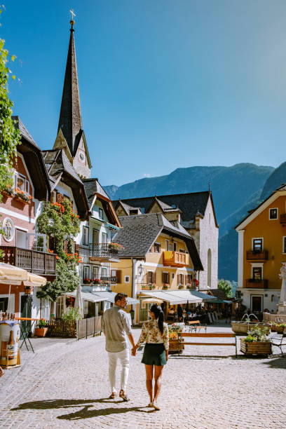 couple visit hallstatt village on hallstatter lake in austrian alps austria - áustria alta imagens e fotografias de stock