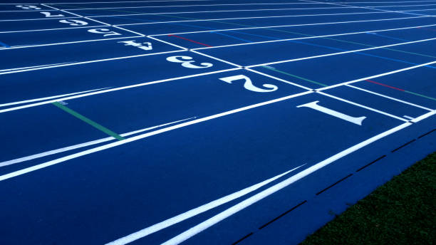 Blue Running Track with White Lane Numbers and Turf Blue Running Track with White Lane Numbers and Turf distance running stock pictures, royalty-free photos & images