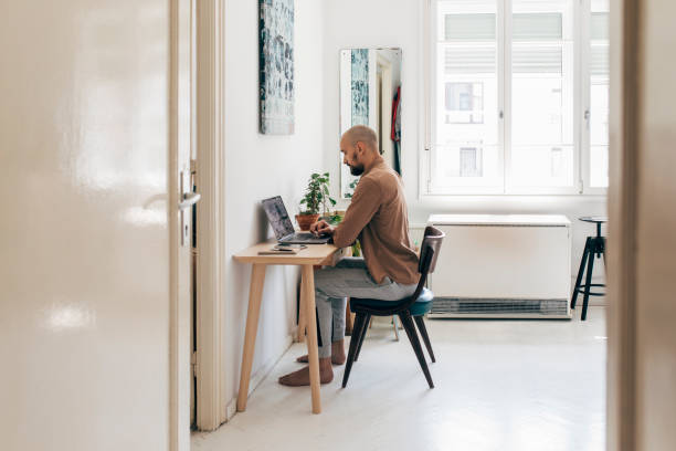 istock At the Home Office: a Young Man Working on his Laptop Computer at Home 1266355073