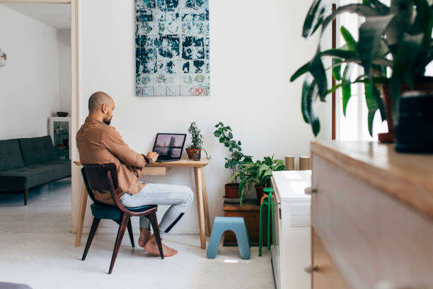 istock At the Home Office: a Young Man Working on his Laptop Computer at Home 1266355083