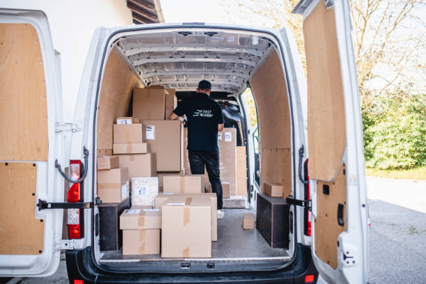 istock Independent Delivery Driver Organizing Parcels on Van 1266361414