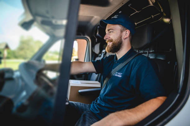 Cheerful Male Uniformed Gig Delivery Driver Sitting in Van
