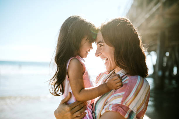 istock Mother Holds Her Daughter at the Beach 1266364878