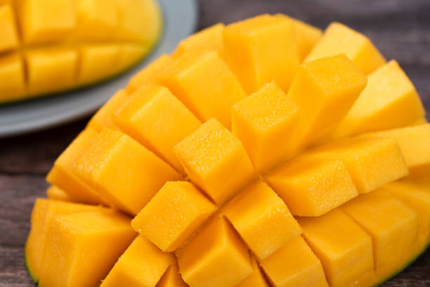 istock mango slice with green leaves isolated on wooden background 1266364993
