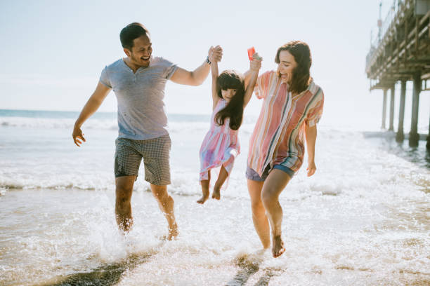 liebende familie genießt sonne am strand von los angeles - spielerisch fotos stock-fotos und bilder
