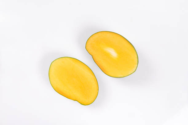 istock mango slice with green leaves isolated on white background 1266365045