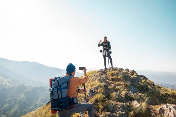 istock Young couple taking pictures while out hiking 1266371288