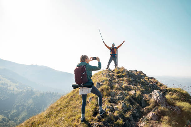 istock Young couple taking pictures while out hiking 1266371326