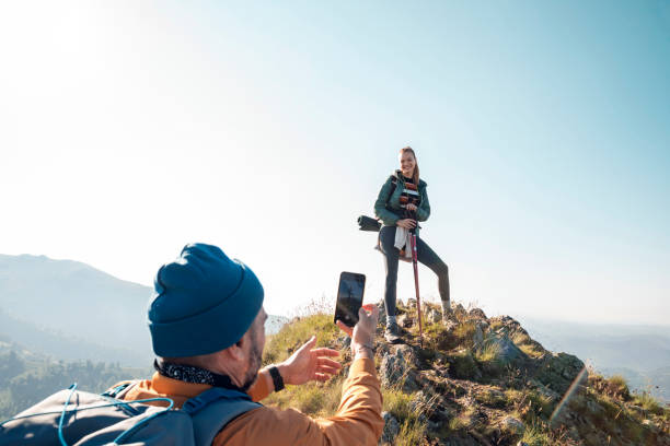 istock Young couple taking pictures while out hiking 1266372306
