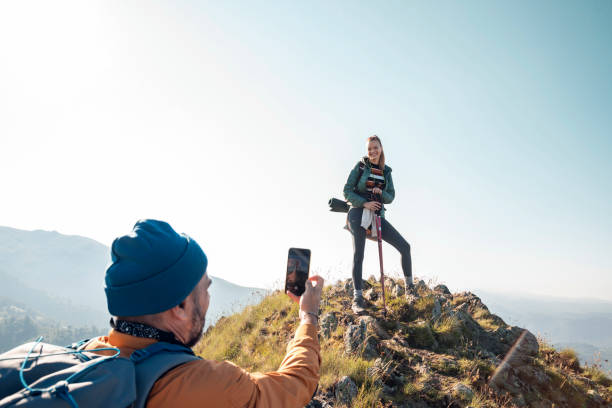 istock Young couple taking pictures while out hiking 1266372838