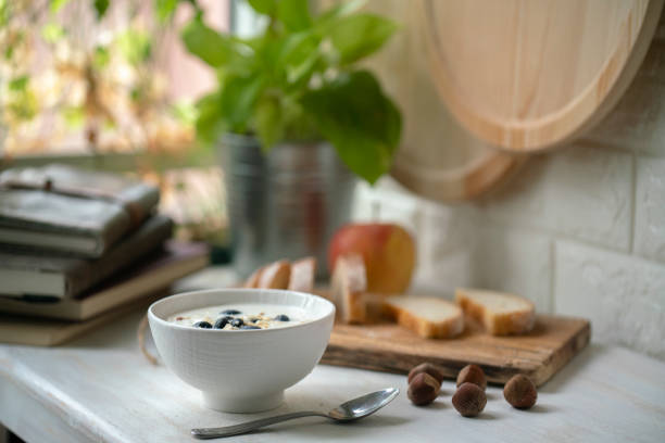 homemade yogurt,toasted bread and books on table beside window