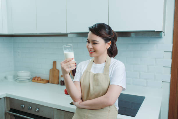 istock asian woman drink milk in the kitchen 1266383725