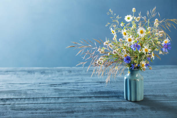 istock wild flowers in vase on blue background 1266383851