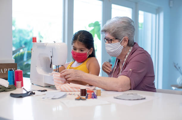 istock Teaching my granddaughter to use a sewing machine at home 1266384091