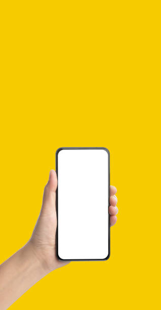 istock mockup hand holding mobile blank screen on yellow background.mockup banner display of content to advert on media.Clipping path on both hand and smartphone screen 1266384879