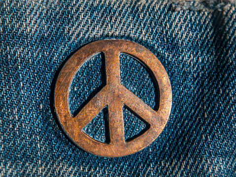 Iron sign of a pacifist on denim. The symbol of the struggle for peace. Ideology. Place for your text. Background image. Denim clothing.
