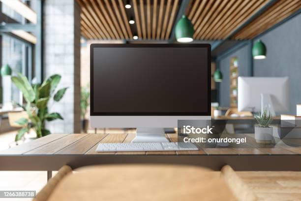 Blank Screen Computer On Table With Office In The Background Stock Photo - Download Image Now