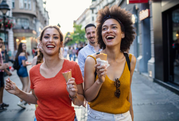 istock Female friends having fun and eating ice cream 1266389875