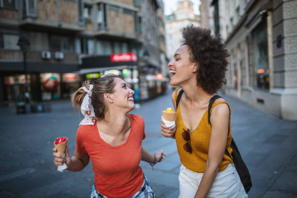 istock Female friends having fun and eating ice cream 1266389895