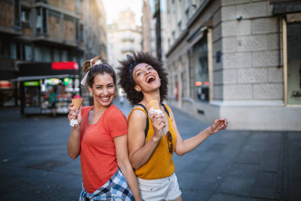 istock Female friends having fun and eating ice cream 1266389942