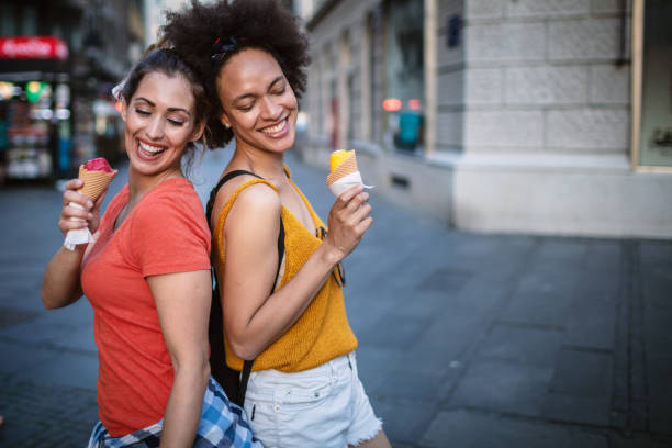istock Female friends having fun and eating ice cream 1266389955
