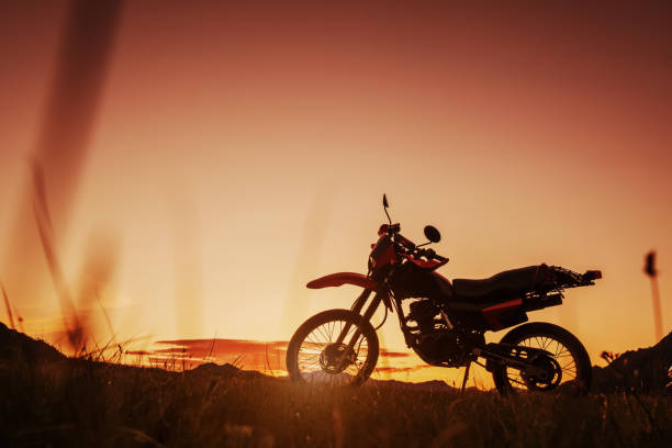 istock Enduro motorcycle silhouette in summer field on sunset 1266391312