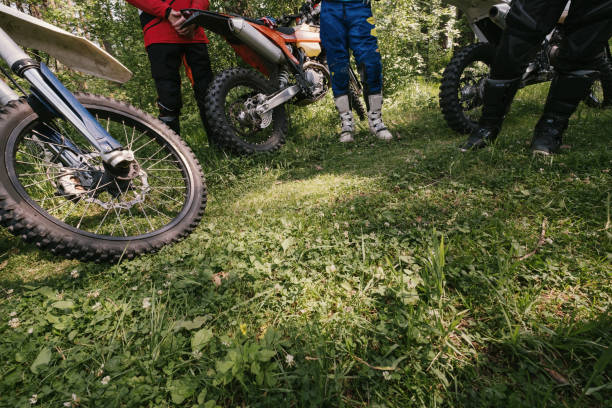 istock Cross offload bikes, riders standing in the forest 1266392301