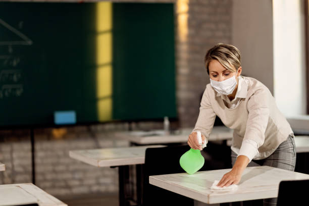 istock Elementary school teachers disinfecting classroom tables. 1266398795
