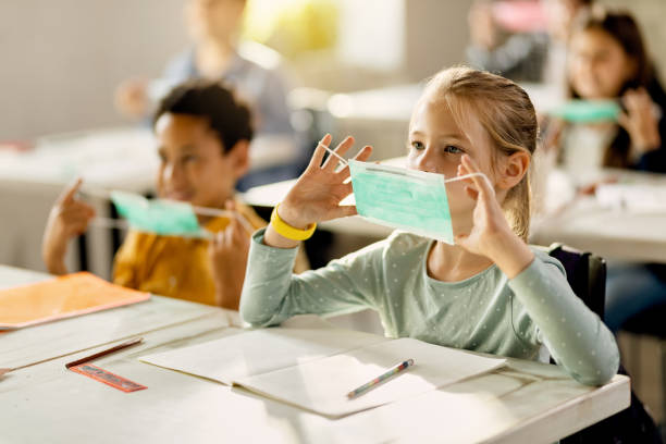 istock Elementary students learning how to properly wear a mask during a class at the school. 1266399552