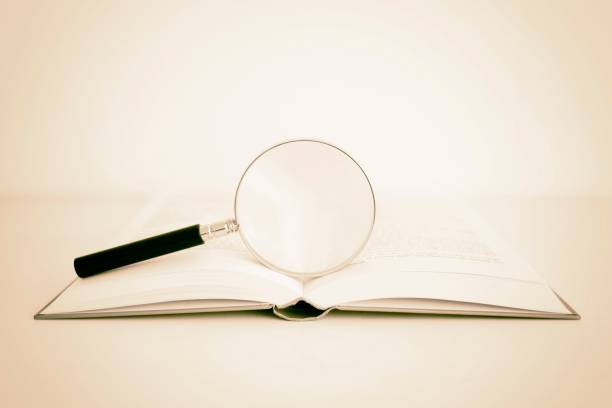 istock Magnifying glass in the open book 1266401420