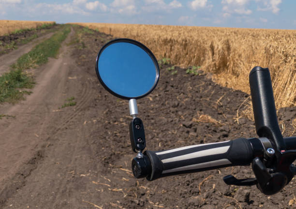 Vista del ciclista en un camino terrestre al lado del campo de trigo - foto de stock