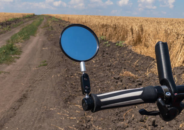 View from bicycle rider  on an earth road beside wheat field - fotografia de stock