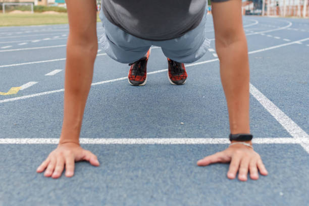 istock Sport man doing push ups exercise on the blue running track in stadium. 1266408646