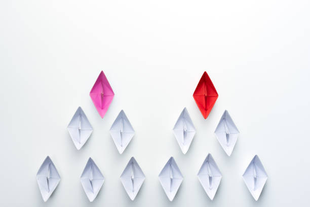 istock Red and pink paper ship leading among white. Equality or Competition for leadership between men and women concept. 1266408831