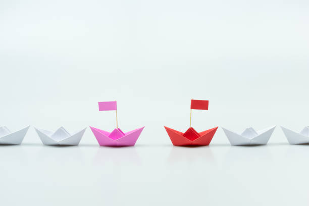 istock Red and pink paper ship leading among white. Equality or Competition for leadership between men and women concept. 1266408840