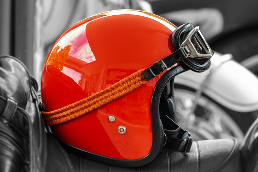 nostalgic red motorcycle helmet lies on the seat of the motorcycle