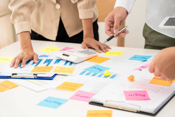 istock Creative group of business people brainstorming use sticky notes to share idea on table or table in office 1266410796
