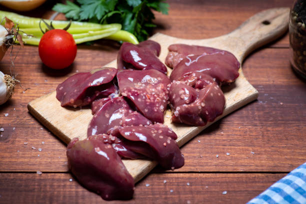 fígado de frango fresco em uma tábua de corte com ingredientes de cozimento - city chicken - fotografias e filmes do acervo
