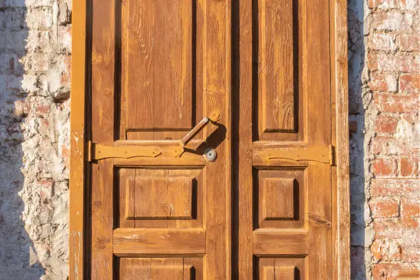 Old wooden door fragment in brick house.