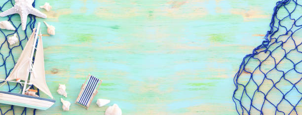 istock nautical concept with white decorative sail boat, seashells over blue wooden background 1266415410