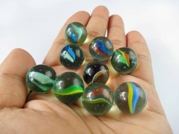 istock Human hands hold many colorful marbles on white background. 1266416776