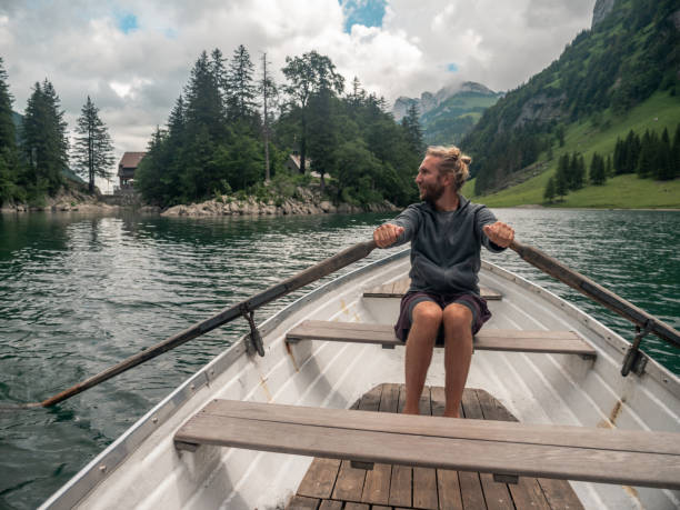 istock Man on rowing boat on alpine lake 1266418919