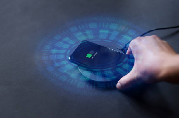 Hand that connects the phone to the wireless charger. Modern technology concept.