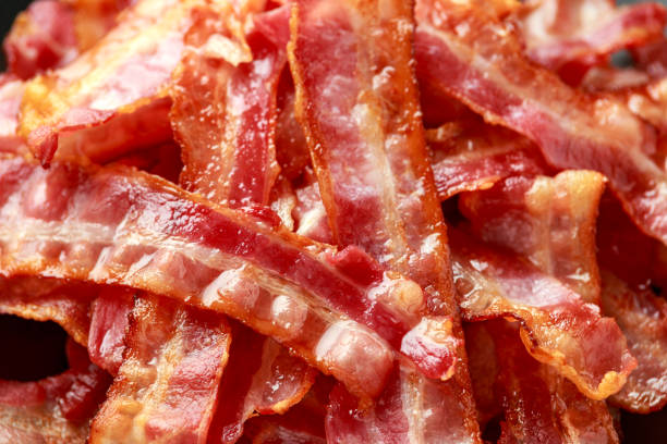 istock Fried crunchy Streaky Bacon pieces in a black plate 1266422060