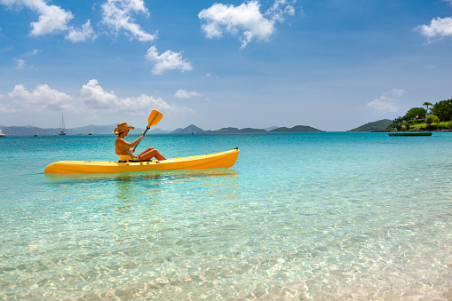 attractive woman on a kayak at tropical beach in the caribbean, St. John, United states virgin islands